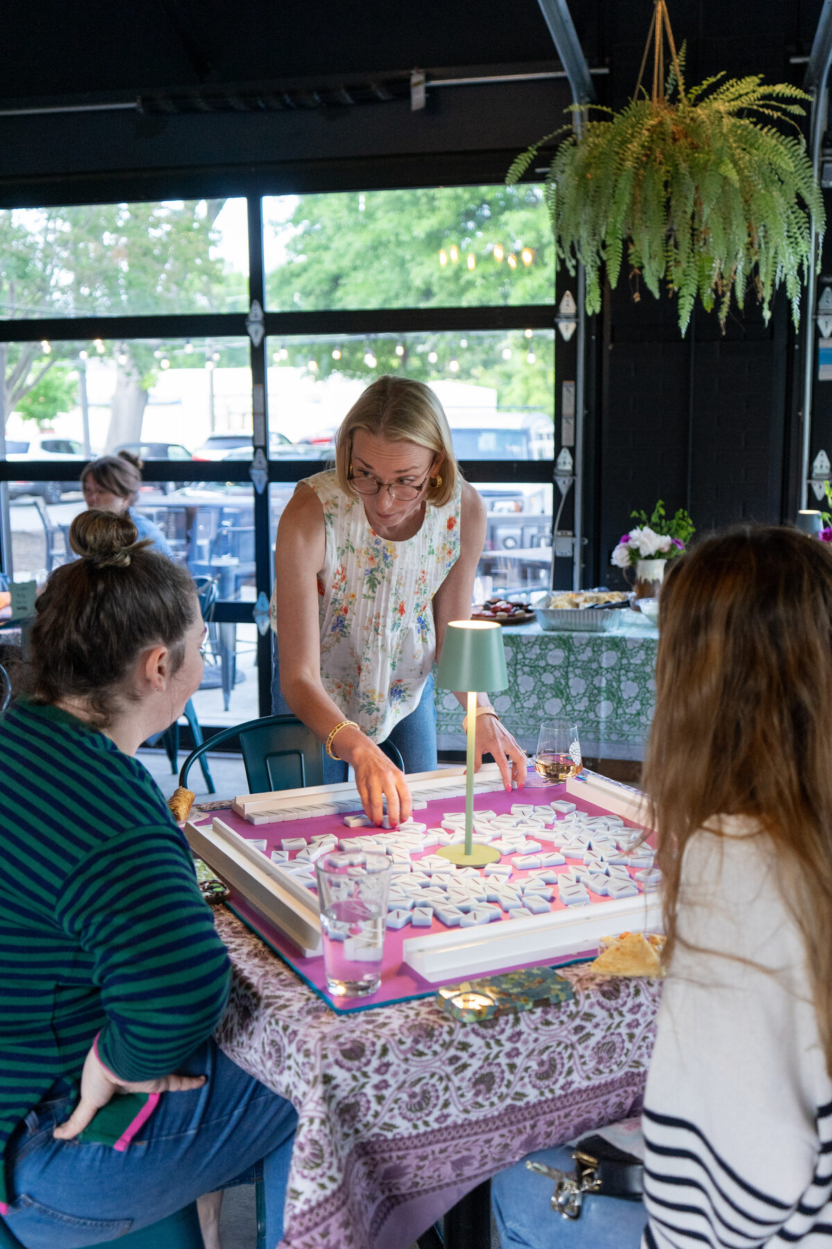 A group of friends laughing around the mahjong table