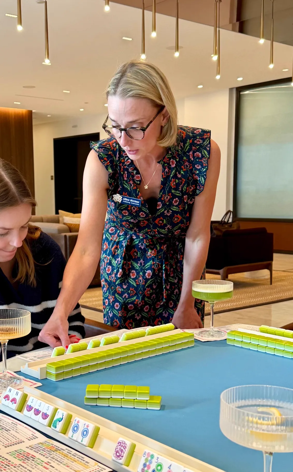 Allison teaching a beginner mahjong night across multiple tables